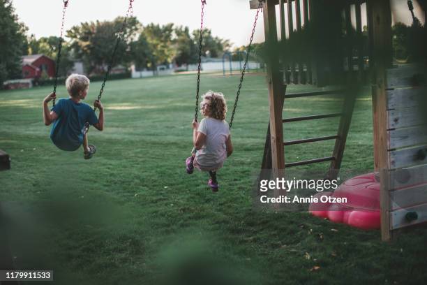 back view of children swinging - children only stock pictures, royalty-free photos & images