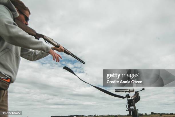 man launching clay pigeons - clay shooting stockfoto's en -beelden