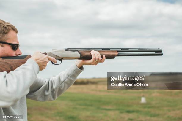 man aiming shotgun - shotgun stock pictures, royalty-free photos & images