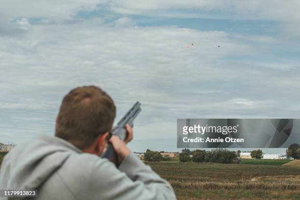 man shooting clay pigeons - clay shooting stockfoto's en -beelden