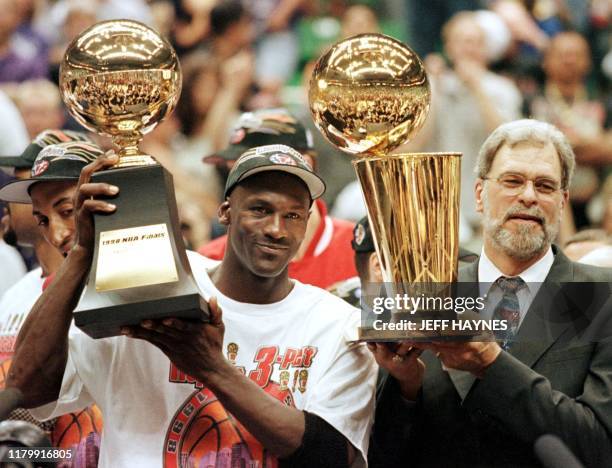 Michael Jordan and Chicago Bulls head coach Phil Jackson Most Valuable Player trophy and the Larry O'Brian trophy 14 June after winning game six of...