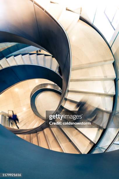 motion blur of speeding person on abstract spiral staircase - lonely businessman alone late at work stock pictures, royalty-free photos & images