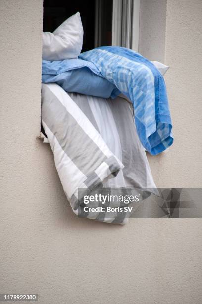 bed linen drying up in open window - drying stock pictures, royalty-free photos & images