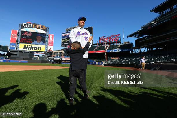 Carlos Beltran poses for pictures as his son Evan Carlos approaches after being introduced as the next manager of the New York Mets during a press...