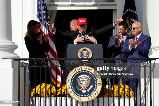 Catcher Kurt Suzuki wears a "Make America Great Again" hat as he is hugged by U.S. President Donald Trump as he welcomes the 2019 World Series...