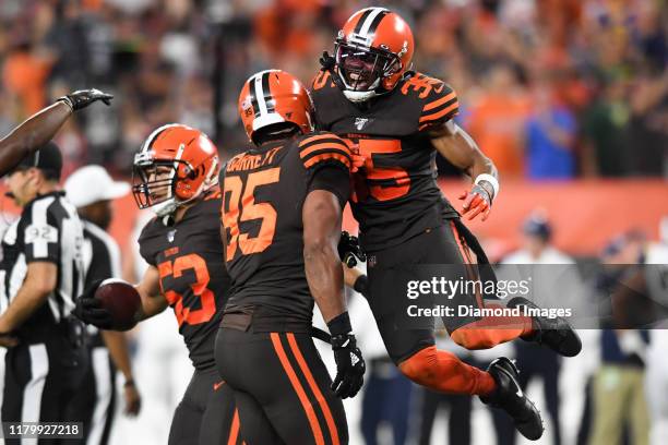 Defensive back Jermaine Whitehead and defensive end Myles Garrett of the Cleveland Browns celebrate a fumble recover by middle linebacker Joe...