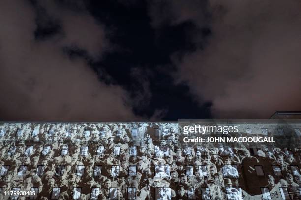 Photo showing a mass demonstration in the former east Germany is projected on the walls of the former Stasi headquarters during the city-wide...