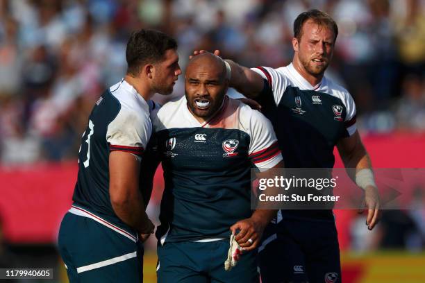 Paul Lasike of the United States is consoled by his team mates Bryce Campbell and Ben Pinkelman after the Rugby World Cup 2019 Group C game between...