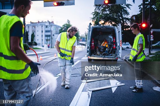 Construction Crew Mitglied Spray Malerei Turn Arrow bei Dämmerung Construction Crew Mitglied Spray Malerei Turn Arrow bei Dämmerung