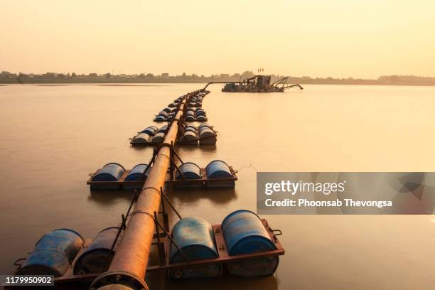 dredging boat carrying a sand pumping machine near mekong riverbank in vientiane, laos - river mekong stockfoto's en -beelden
