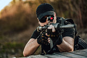 Close-up image of man aiming with sniper rifle.