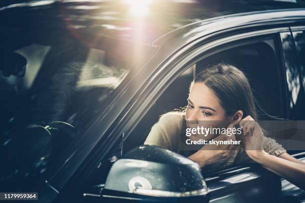 車の中でイヤリングを調整する美しい女性。 - adjusting ストックフォトと画像