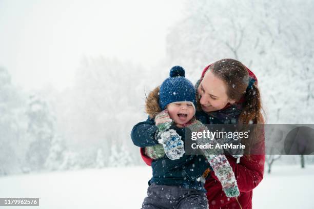 happy child trying to catch snowflakes in winter outdoors - catching snow stock pictures, royalty-free photos & images