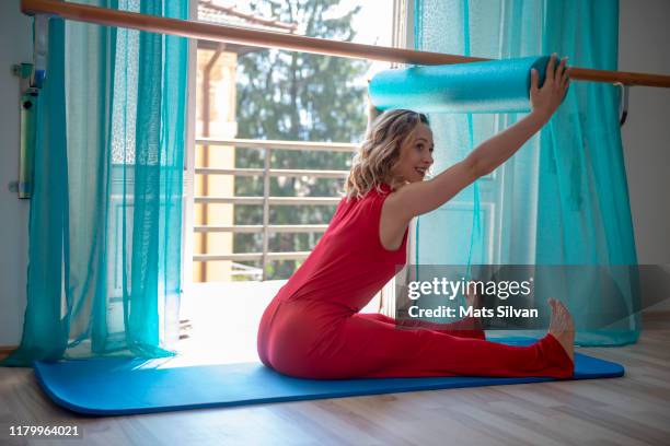 woman exercising pilates on mat with arms in the air - mats silvan stock pictures, royalty-free photos & images