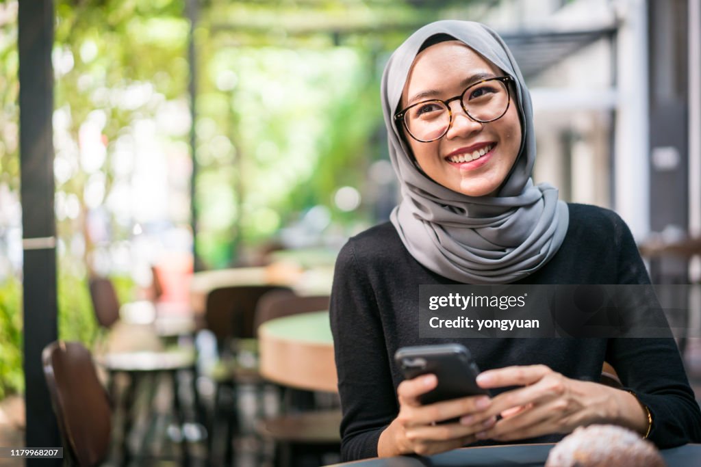 Alegre empresaria malasia en un café