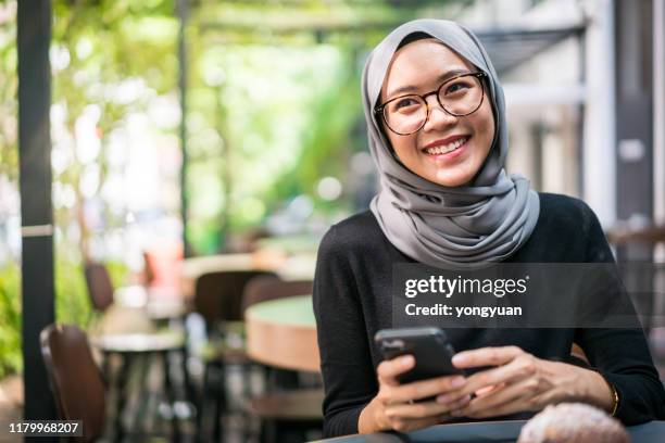alegre empresaria malasia en un café - malásia fotografías e imágenes de stock