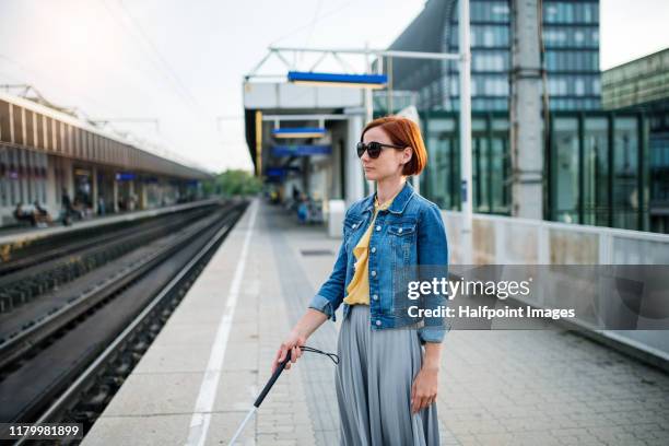 portrait of blind woman with white cane standing outdoors in city. - blind person stock pictures, royalty-free photos & images