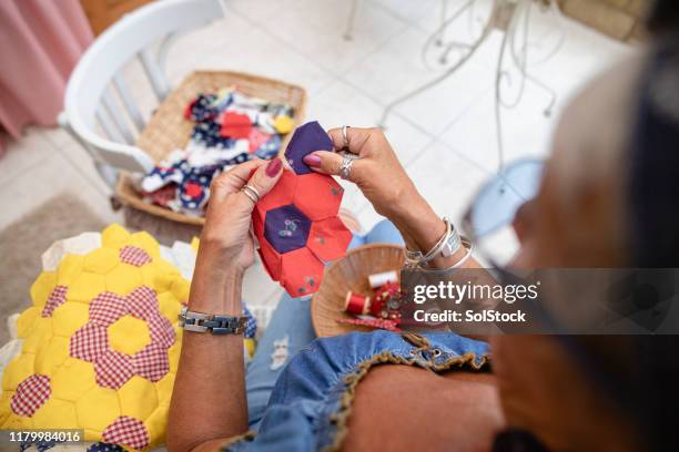 she is re-using some old fabric - patchwork stockfoto's en -beelden