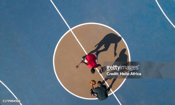 aerial shot of 2 basketball players and shadows - overhead view photos et images de collection