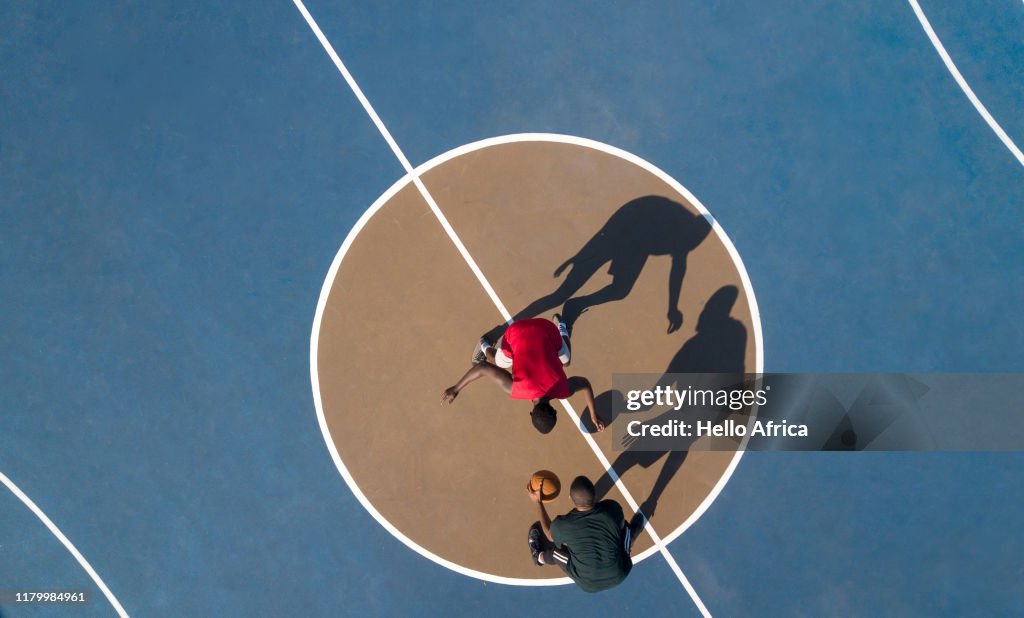 Aerial shot of 2 basketball players and shadows
