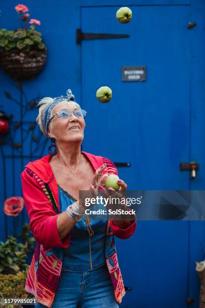 senior woman juggling apples - eccentric stock pictures, royalty-free photos & images
