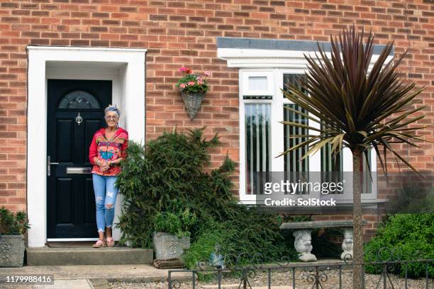 proud of her home - woman standing in doorway stock pictures, royalty-free photos & images