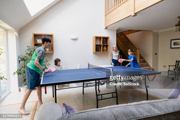 family enjoying a game of table tennis - game room 個照片及圖片檔