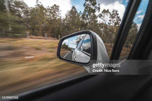 looking into the side mirror of a moving car - side view mirror stockfoto's en -beelden