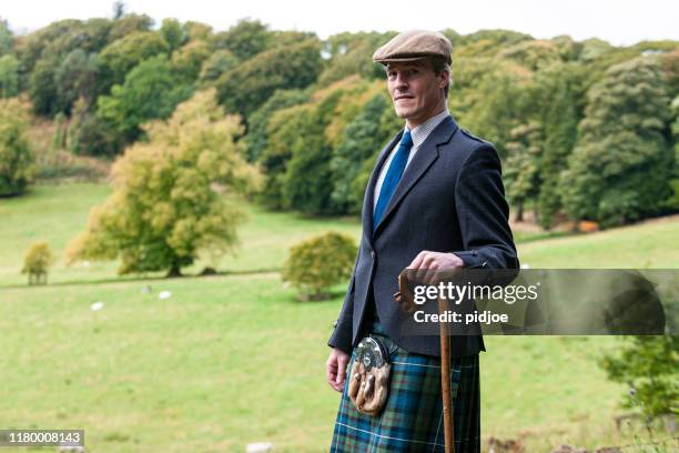 scottish man in kilt and sporran leaning on cane - kilt stock pictures, royalty-free photos & images