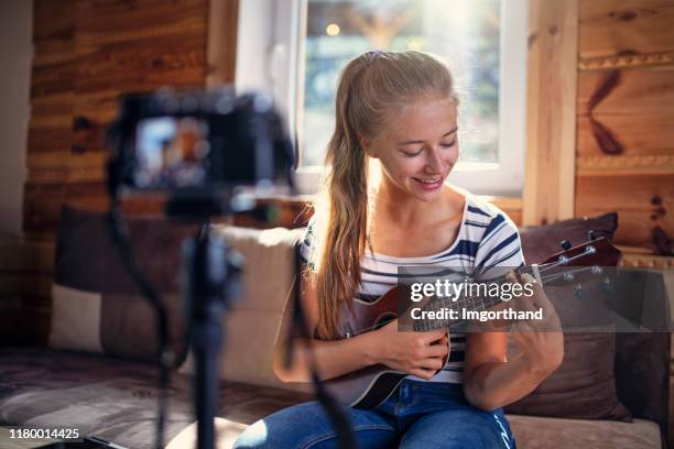 teenage girl teaching how to play ukulele - filming tutorial stock pictures, royalty-free photos & images