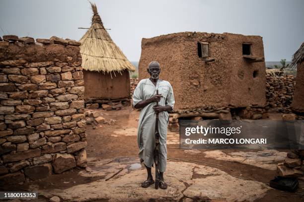 Salifu Dibo, a Dogon farmer and the chief of the community in So, in central Mali's Dogon region, poses for a picture with his hunting rifle on July...