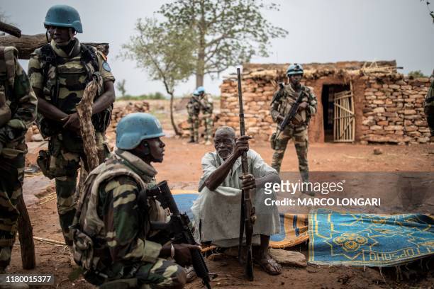Salifu Dibo , a Dogon farmer and the chief of the community in So, in central Mali's Dogon region, sits with his hunting rifle as he is met by...