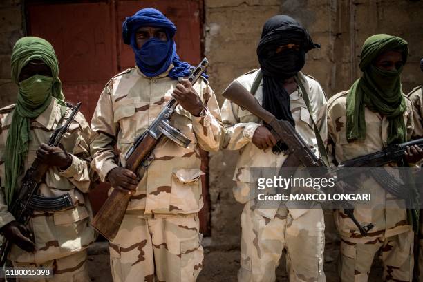 Group of Fulani militiamen pose for a picture with their weapons on July 6 at an informal demobilisation camp in Sevare run by Sekou Bolly, a local...