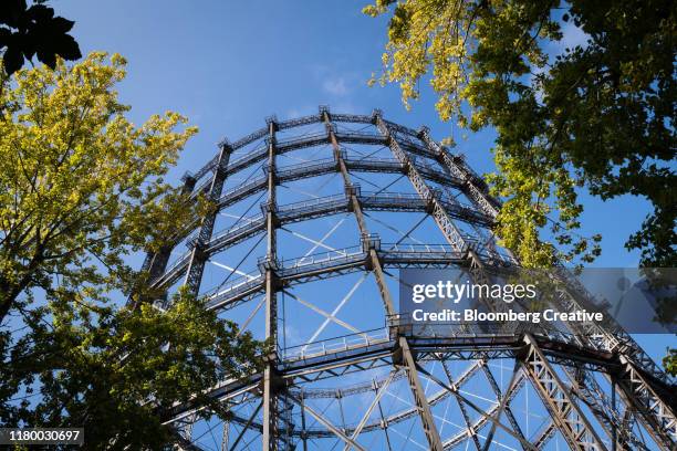 a gasometer against a blue sky - gasometro foto e immagini stock