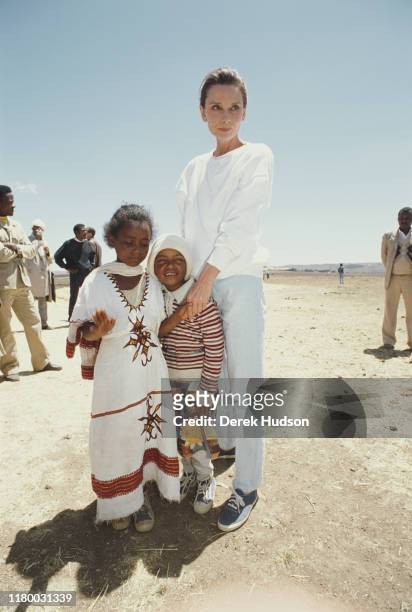 British actress and humanitarian Audrey Hepburn with local children on her first field mission for UNICEF in Ethiopia, 16th-17th March 1988.