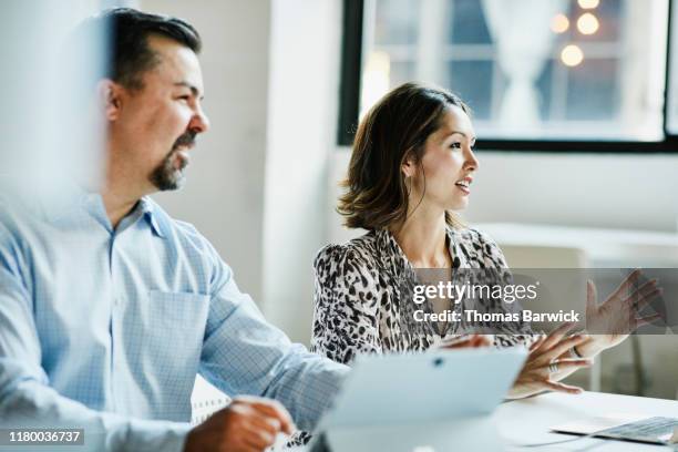 businesswoman leading team meeting in coworking office - evolution woman stockfoto's en -beelden