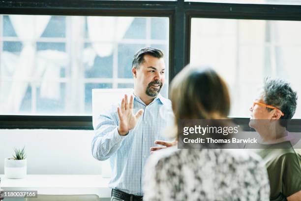 businessman leading project discussion with colleagues during meeting in office - three people talking stock pictures, royalty-free photos & images
