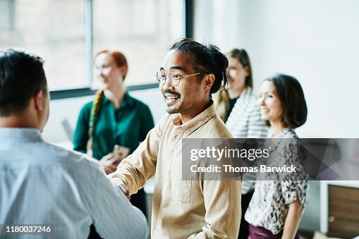 Businessman shaking hands with colleague after meeting in office Businessman shaking hands with colleague after meeting in office