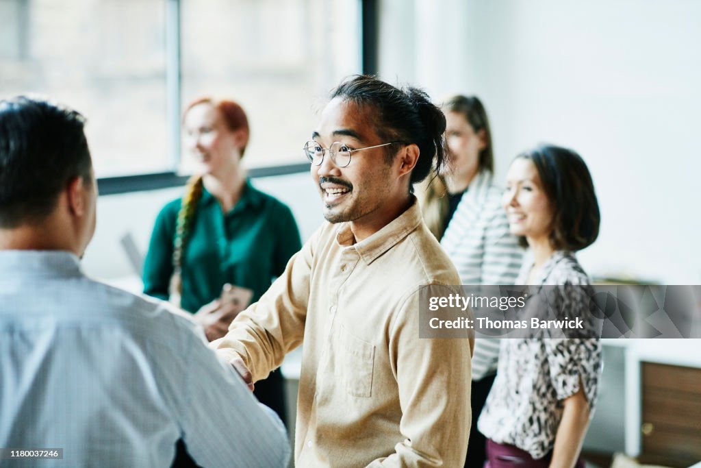 Businessman shaking hands with colleague after meeting in office