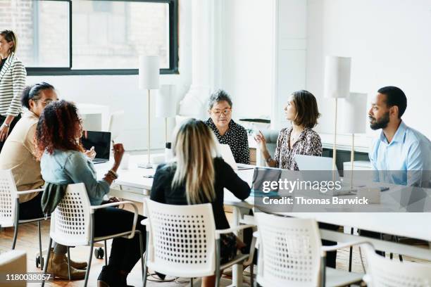 businesspeople working in coworking office - community meeting stock-fotos und bilder