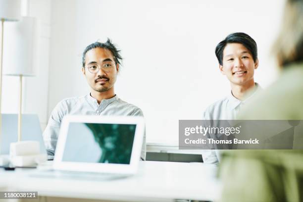 businessmen listening to presentation during meeting in office conference room - filipino ethnicity foto e immagini stock