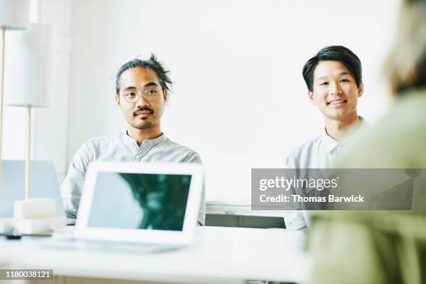 businessmen listening to presentation during meeting in office conference room - filipino ethnicity stock pictures, royalty-free photos & images