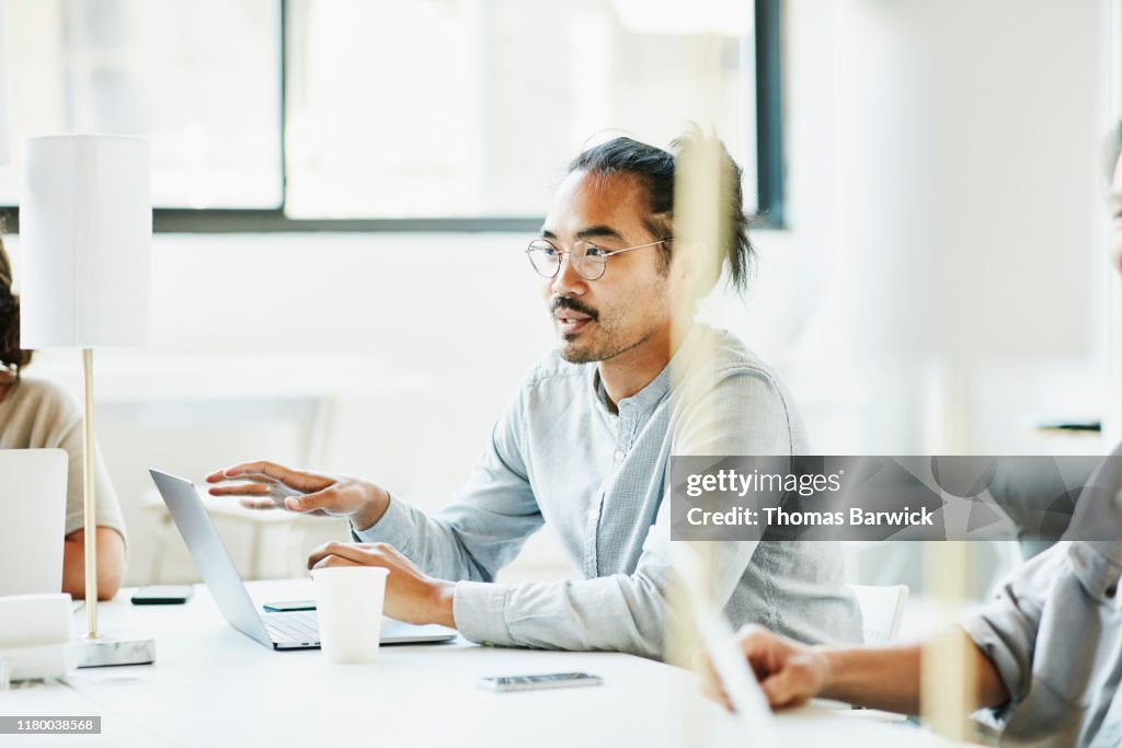 Businessman sharing ideas during team meeting in office conference room