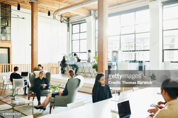 businesspeople working in coworking office space - persona in secondo piano foto e immagini stock