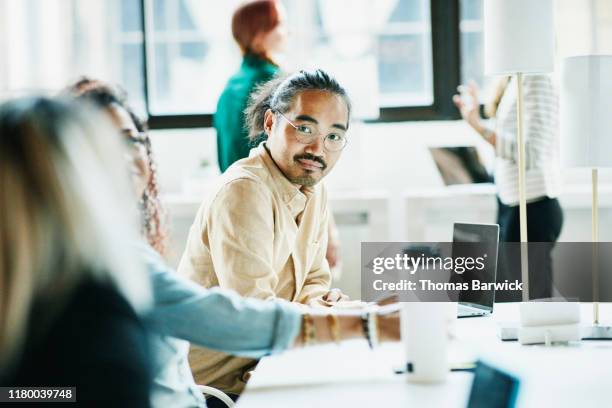 businessman listening to colleague while working in coworking office - cream colored shirt stockfoto's en -beelden