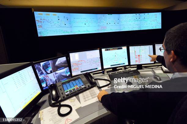 Un agent du Poste de Commande Centralisé de la Ligne 13 montre des postes de contrôle, le 7 décembre 2010 à Malakoff. Sept agents suivent en temps...