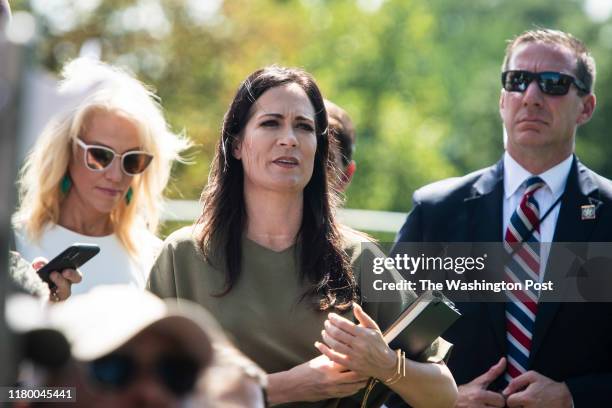 White House Press Secretary Stephanie Grisham listens as President Donald J. Trump stops to talk to reporters and members of the media as he departs...