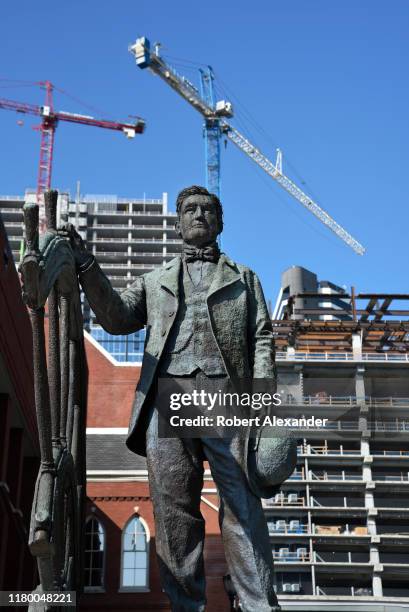 Statue of Thomas Ryman stands in front of the landmark Ryman Auditorium and nearby construction cranes in downtown Nashville, Tennessee. Ryman was a...