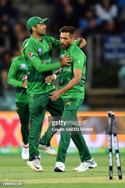 Pakistan's paceman Mohammad Amir celebrates the wicket of Australia's David Warner with a teammate Fakhar Zaman during the second Twenty20 match...