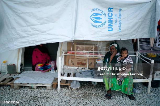 Woman and her child sit in the Moria migrant camp which was built for 3,000 people but now contains over 13,000 on October 09, 2019 in Mytilene,...
